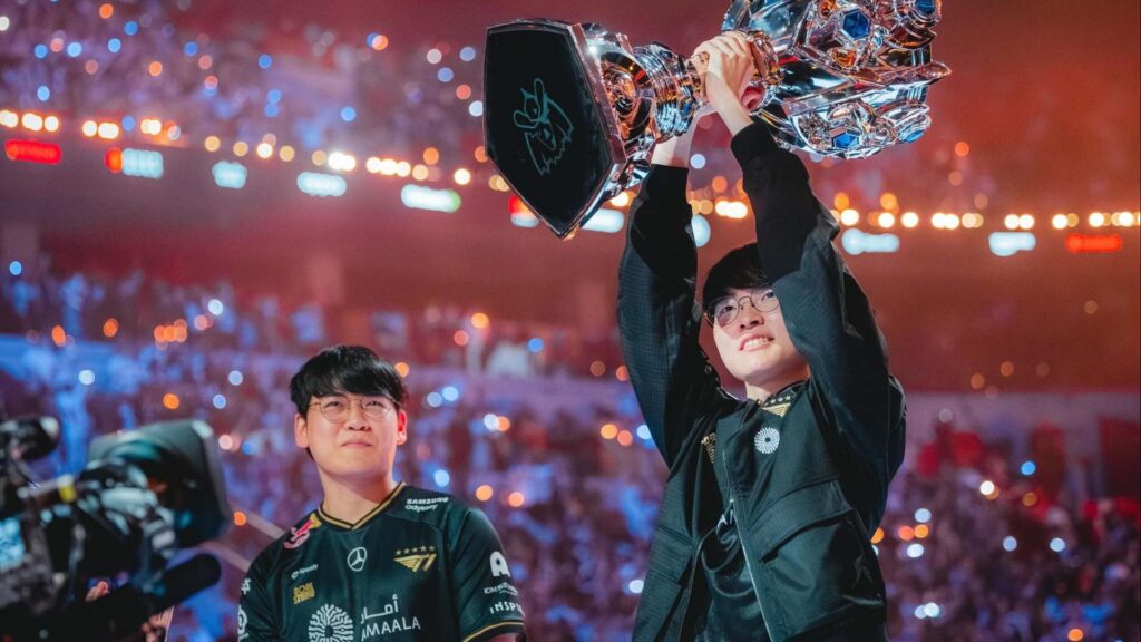 All 11 teams confirmed for Mid-Season Invitational 2026 in Daejeon T1 players, including Faker and Gumayusi, celebrating Worlds victory with the Summoner’s Cup in front of a cheering arena.