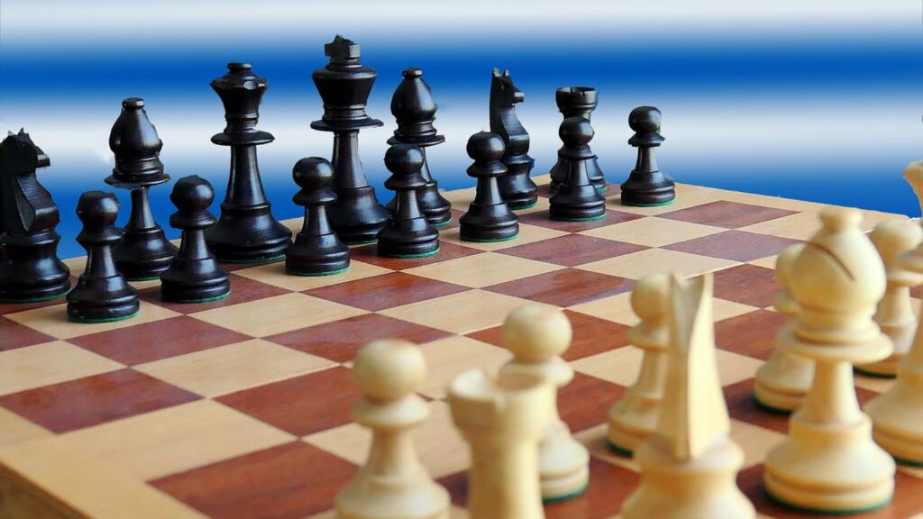 black and white chess pieces set up with blue background