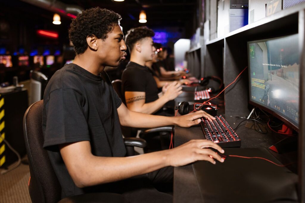 G2 confirms valyn exit as reported Fnatic move would take Americas IGL to EMEA Row of players wearing headsets compete at computer stations in a dimly lit gaming arena